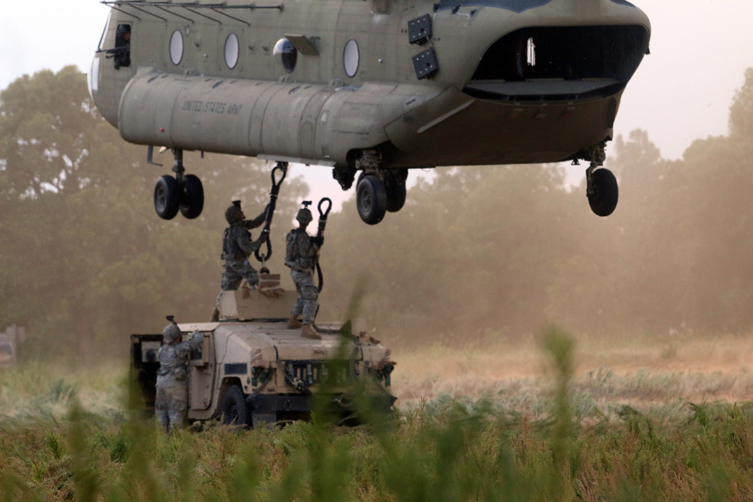 Hooking the load Three paratroopers sling load a M1151 Humvee onto a CH-47 Chinook helicopter.