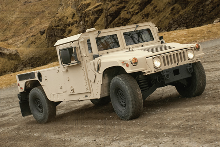 AM General M1152 Humvee drives uphill on off-road trail