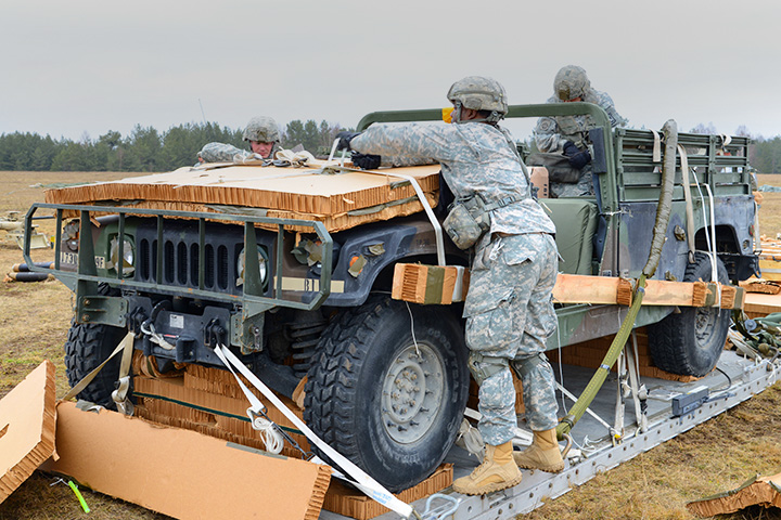 U.S. Army Paratroopers prepare an AM General Humvee that was airdropped by a C-130 Airplane during a training excercise