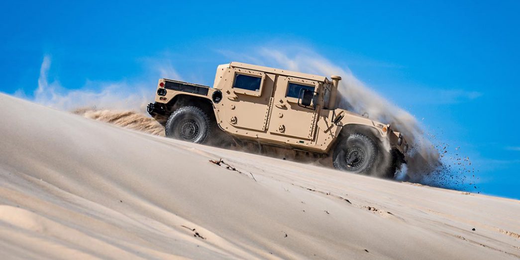 AM General Humvee drives down a sand dune