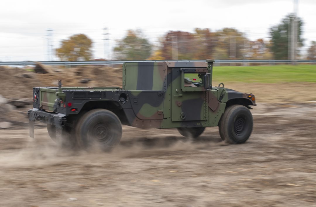 M1152 with Woodland Camo speeds by on an off-road course