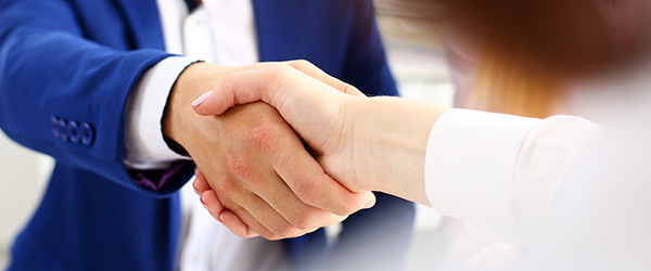 Man in suit shake hand as hello in office closeup